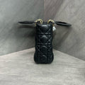 Dior Lady Dior medium (four-compartment) bag in black gold-tone lambskin, produced in 2017, with emblem shoulder strap, structured silhouette, clean interior.