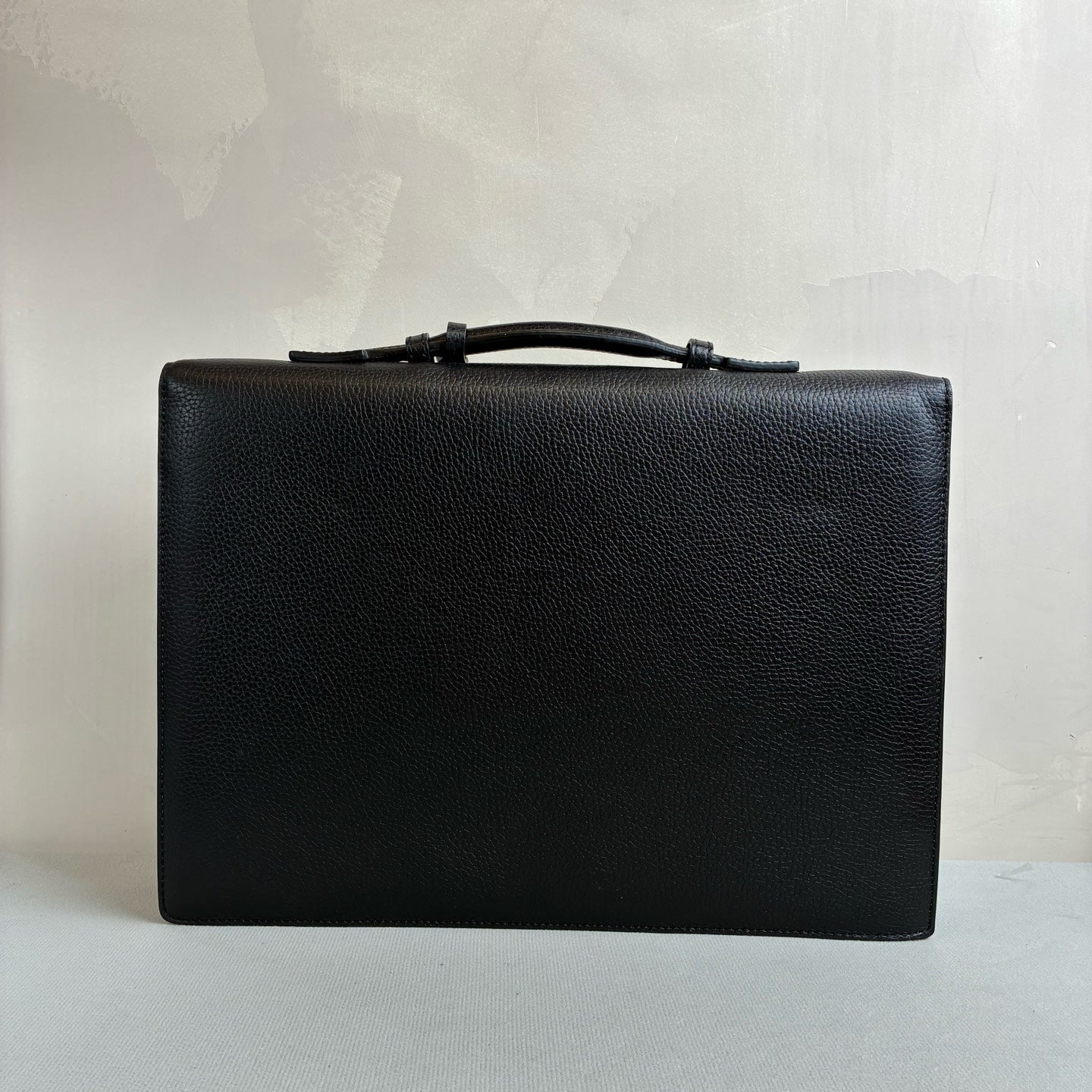 Ermenegildo Zegna This is the Zegna men's briefcase, made of embossed cowhide leather, featuring a lock buckle flap design, primarily targeting business communication.