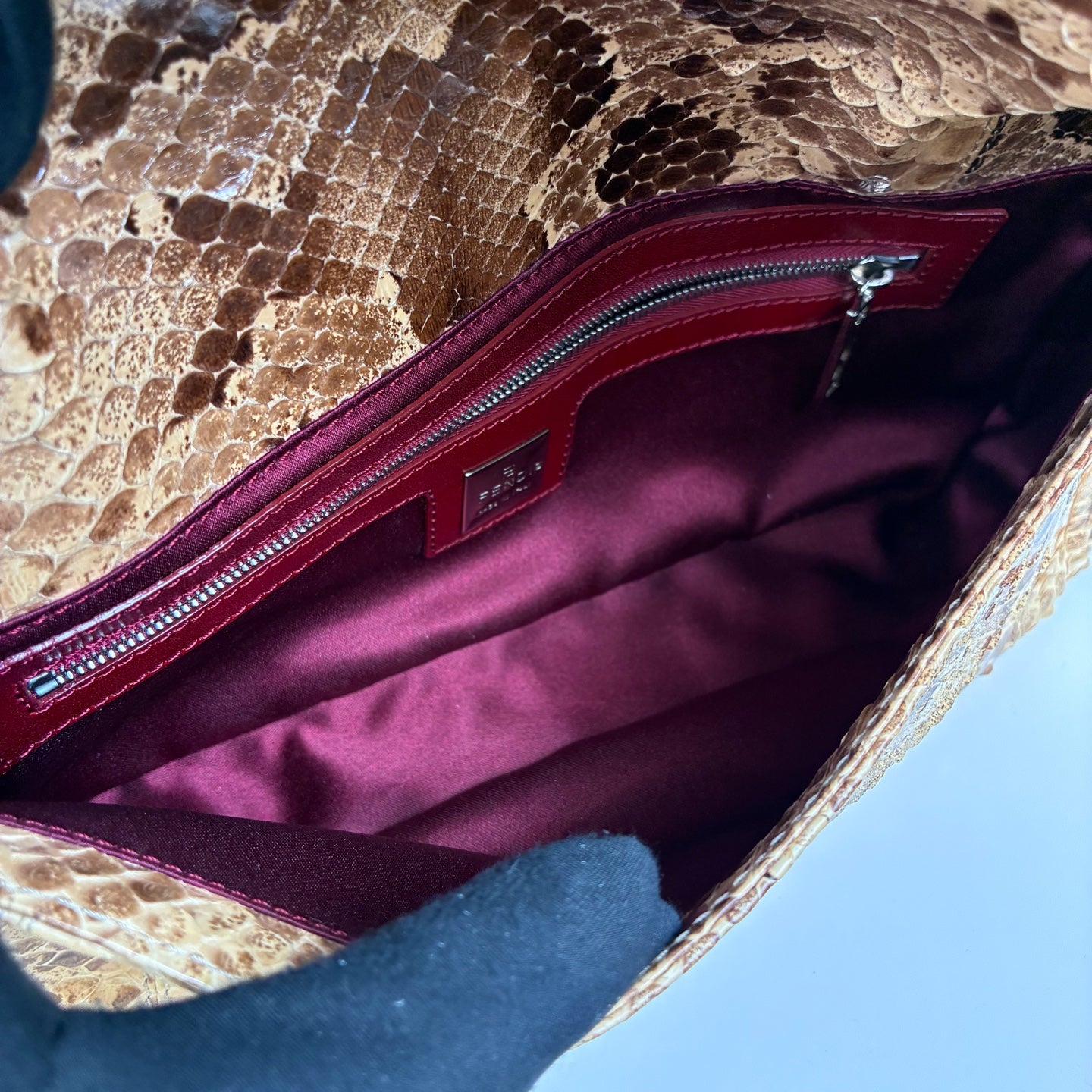 Fendi Snake Skin Silver Rod Baguette Handbag, with a bottom size of 26*12 cm. Classic baguette style, featuring snake skin combined with a red shoulder strap and a silver rod design.