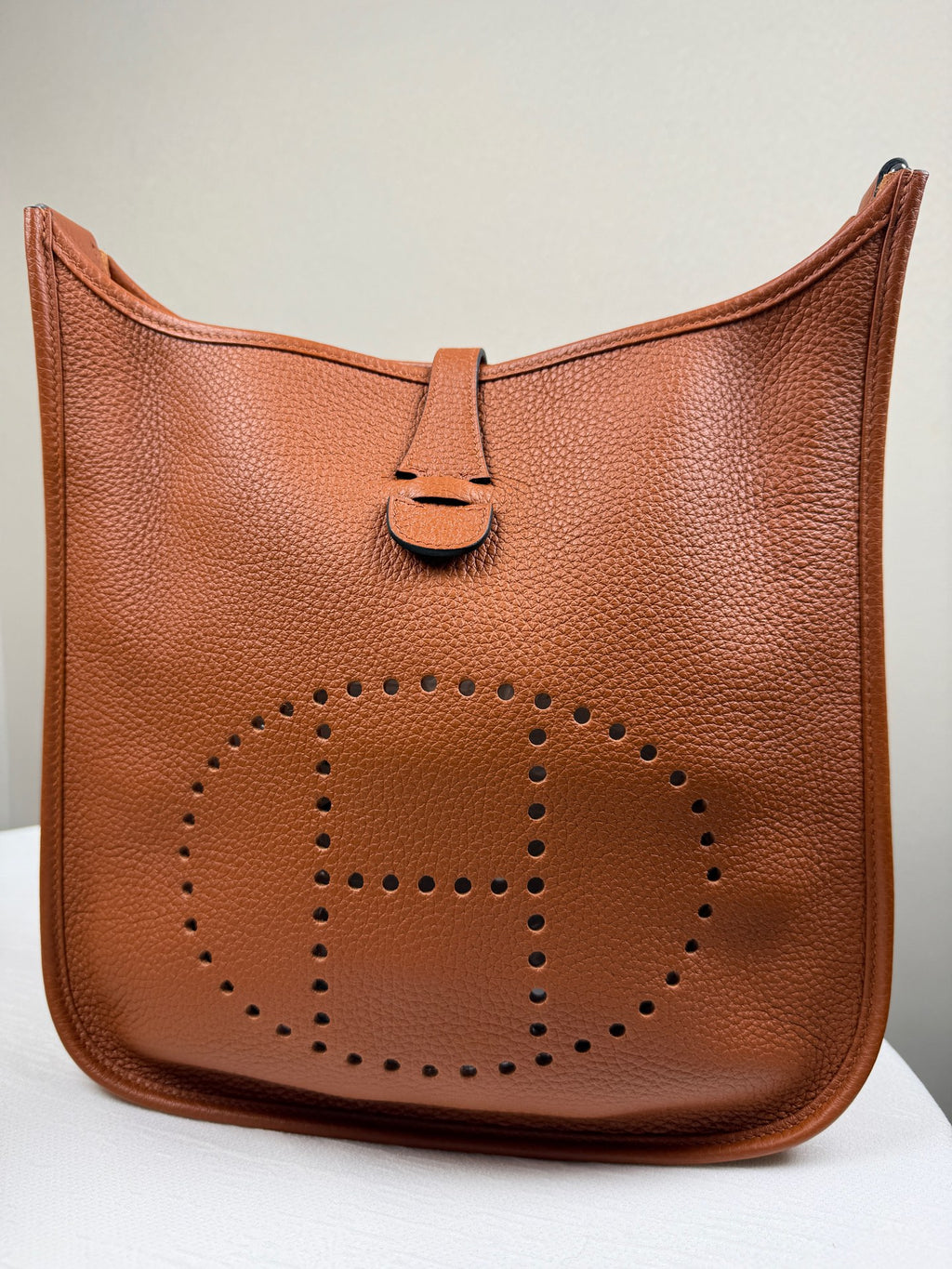 Hermès Evelyne in gold-brown Togo leather, with silver hardware. 98% new classic large H perforated logo design, accompanied by an adjustable shoulder strap.