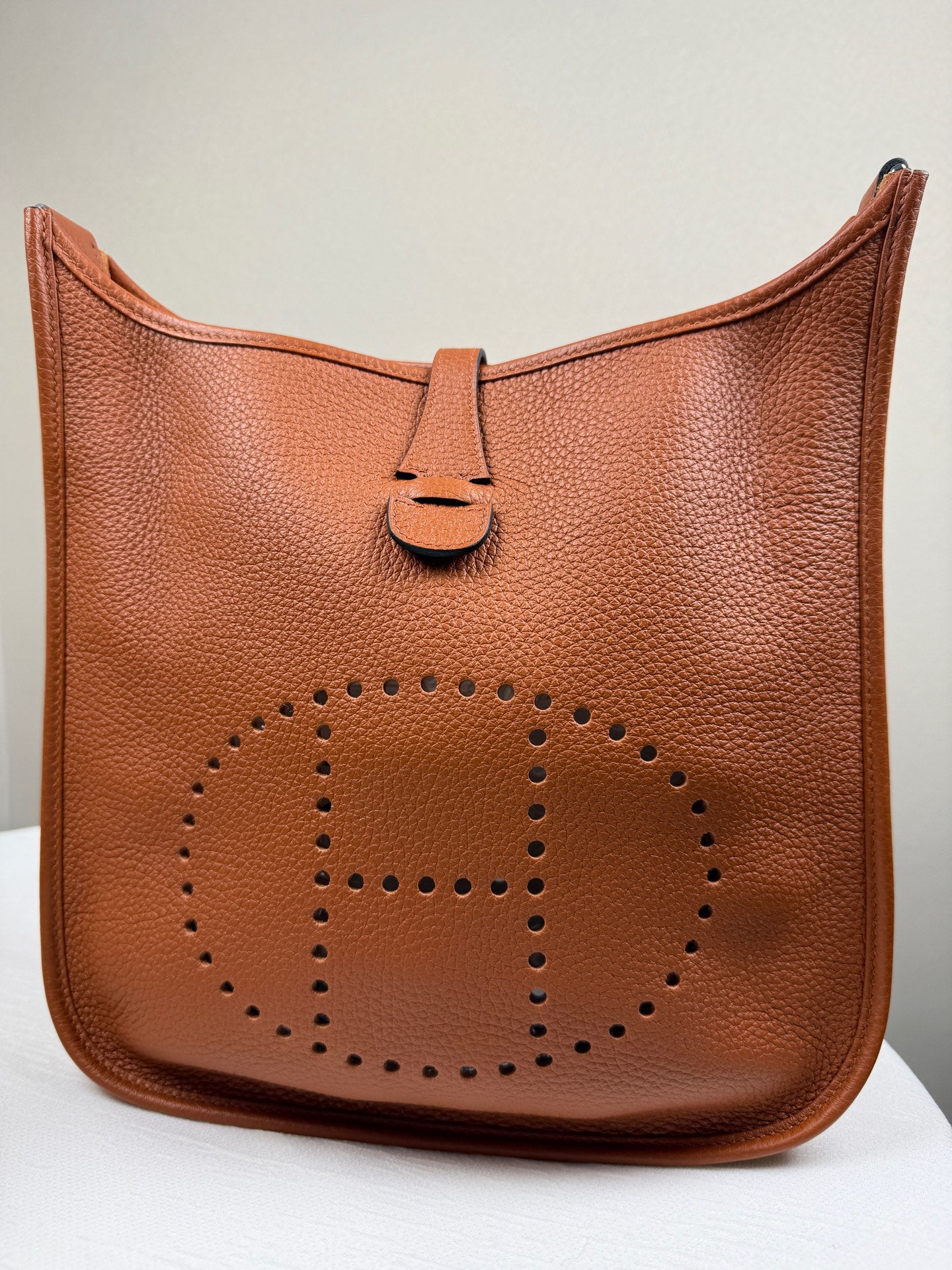Hermès Evelyne in gold-brown Togo leather, with silver hardware. 98% new classic large H perforated logo design, accompanied by an adjustable shoulder strap.