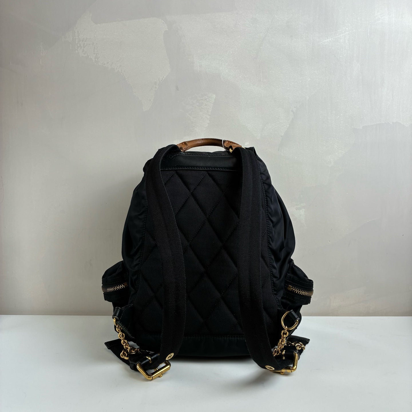 Burberry The Rucksack Series Classic Backpack with Engraving, Classic Black and Gold Color Scheme, Subtle and Sophisticated.
