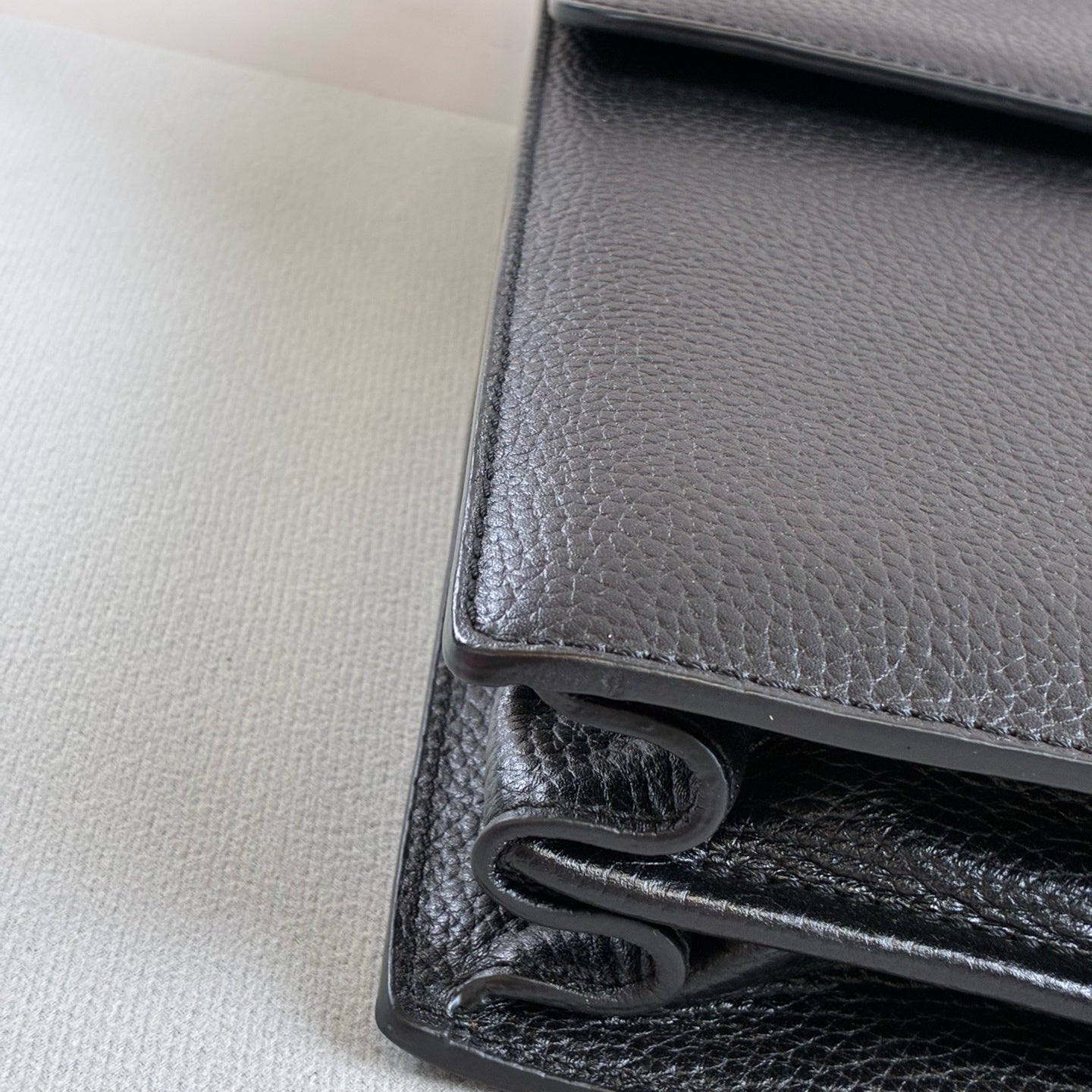 Ermenegildo Zegna This is the Zegna men's briefcase, made of embossed cowhide leather, featuring a lock buckle flap design, primarily targeting business communication.