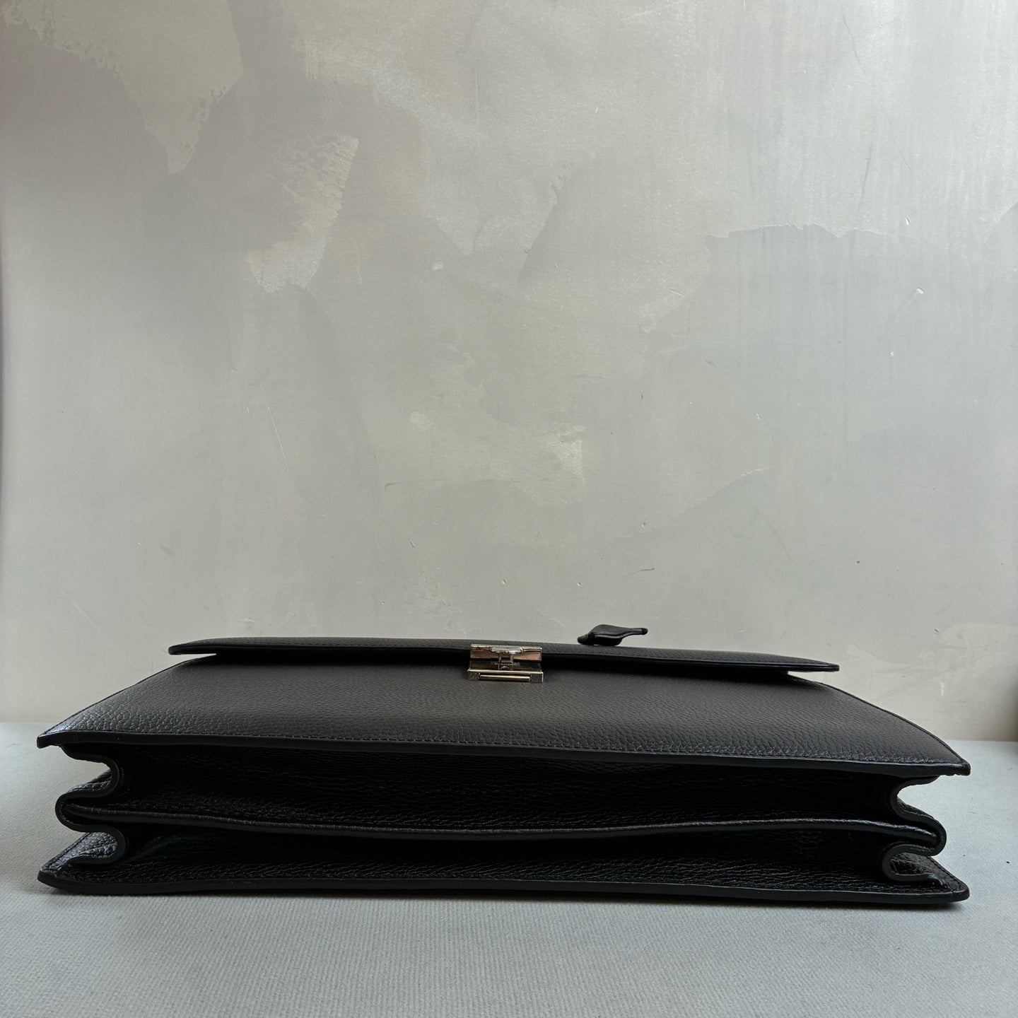 Ermenegildo Zegna This is the Zegna men's briefcase, made of embossed cowhide leather, featuring a lock buckle flap design, primarily targeting business communication.