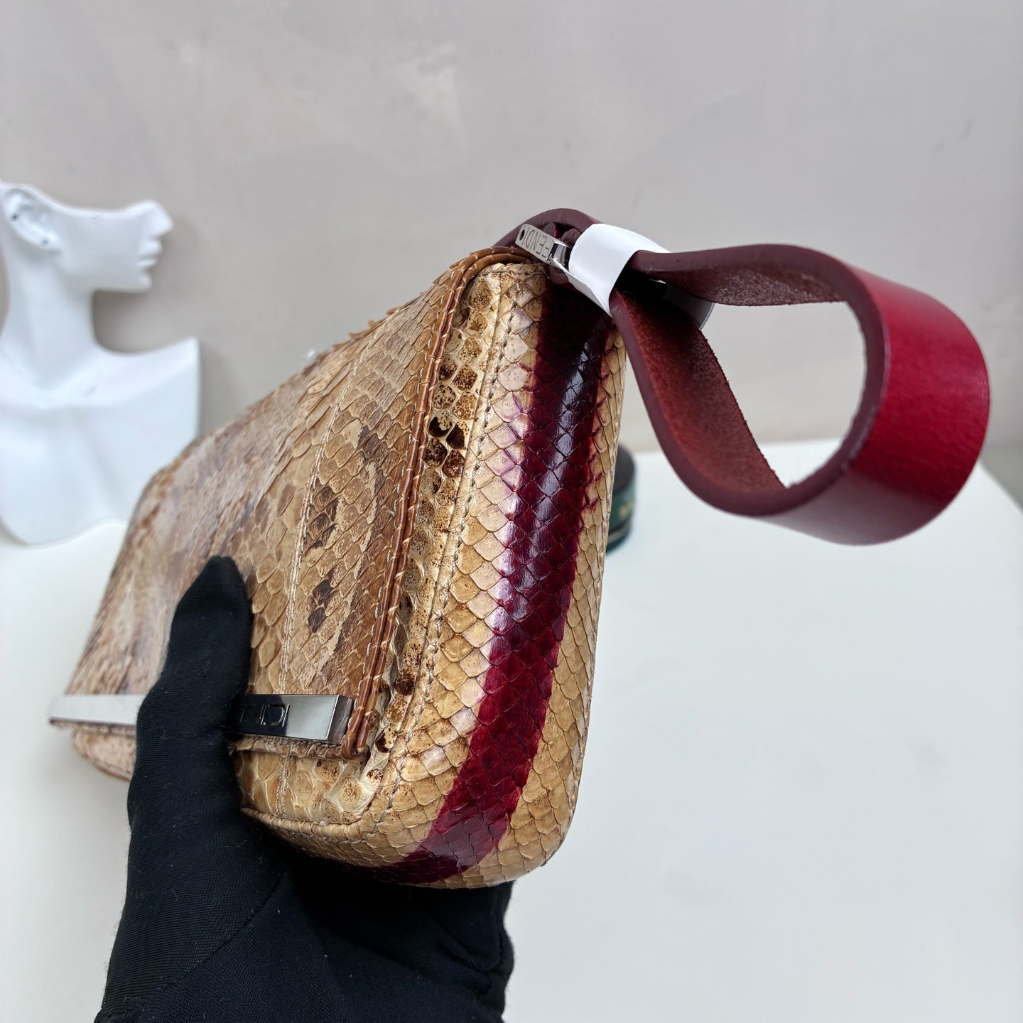 Fendi Snake Skin Silver Rod Baguette Handbag, with a bottom size of 26*12 cm. Classic baguette style, featuring snake skin combined with a red shoulder strap and a silver rod design.